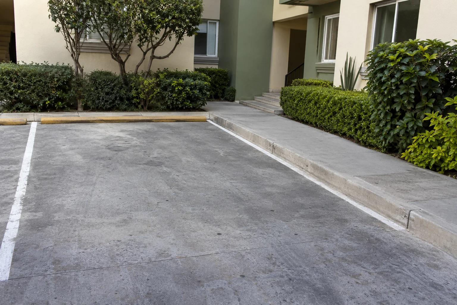 Cajón vacío junto a un paso peatonal despejado en un patio residencial ilustrativo.