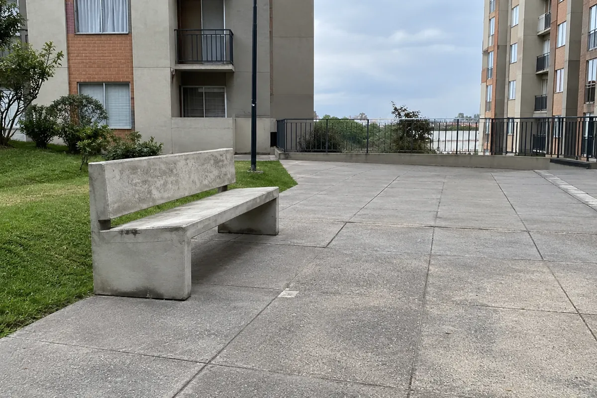 Banca de concreto con espacio libre al costado y enfrente en un patio residencial