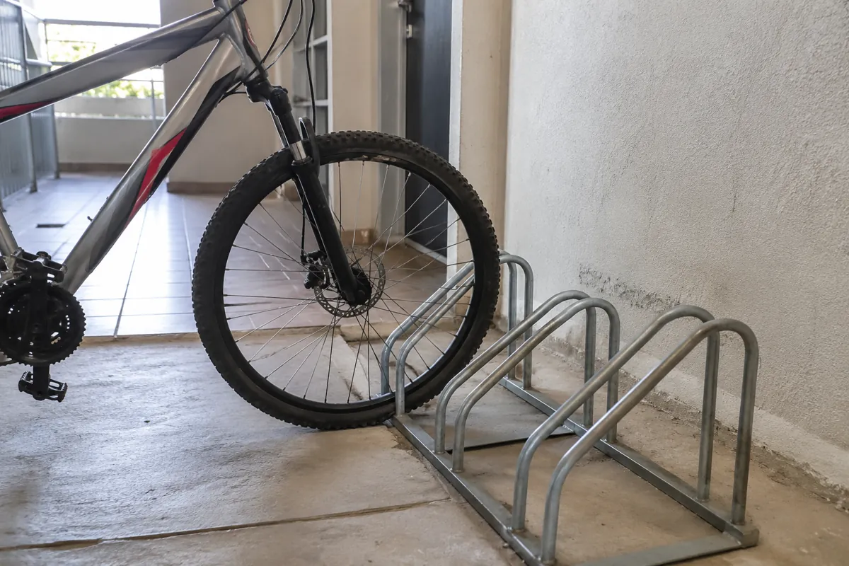 La rueda delantera de una bicicleta está colocada en un soporte metálico