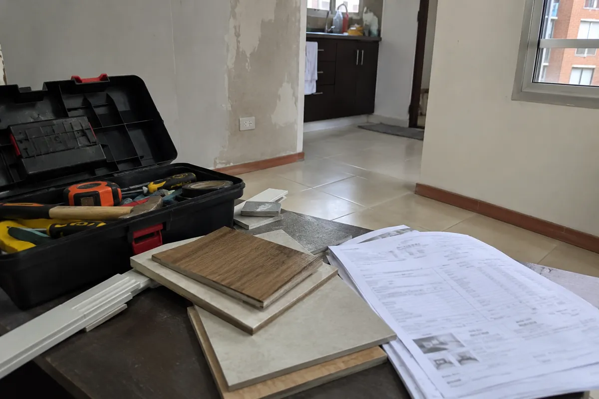 Caja de herramientas abierta junto a muestras de recubrimientos y hojas impresas