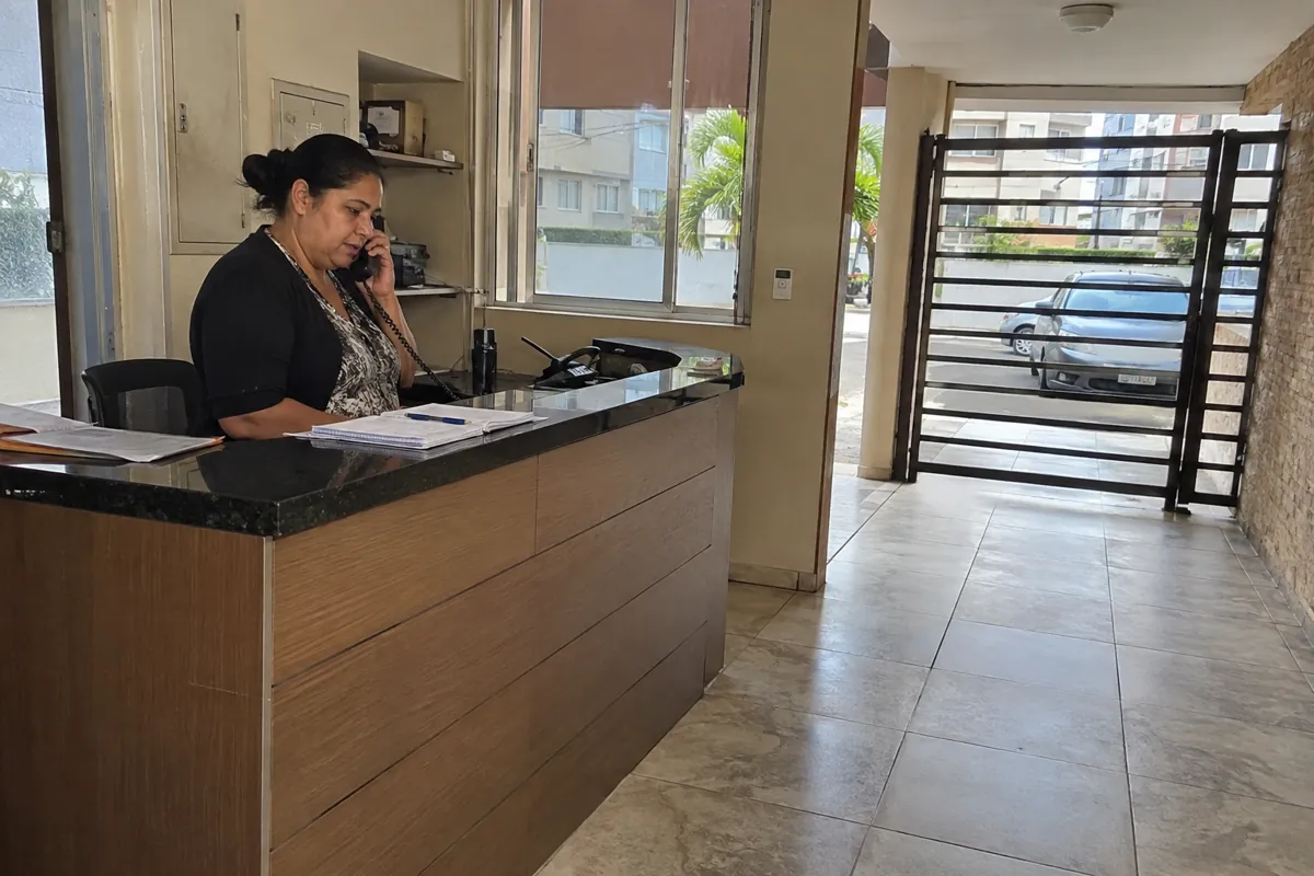 Una mujer habla por teléfono detrás de un mostrador junto a la entrada despejada