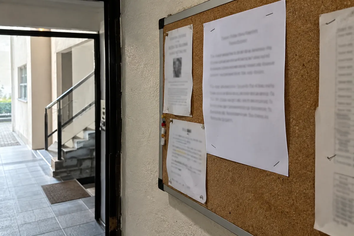 Tablero de corcho con varios avisos de texto borroso en el vestíbulo de un edificio