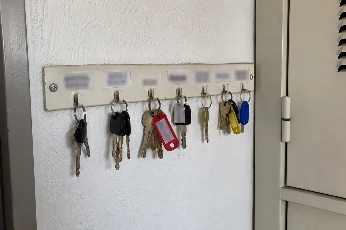 Varios juegos de llaves con etiquetas de colores colgados en un soporte de pared