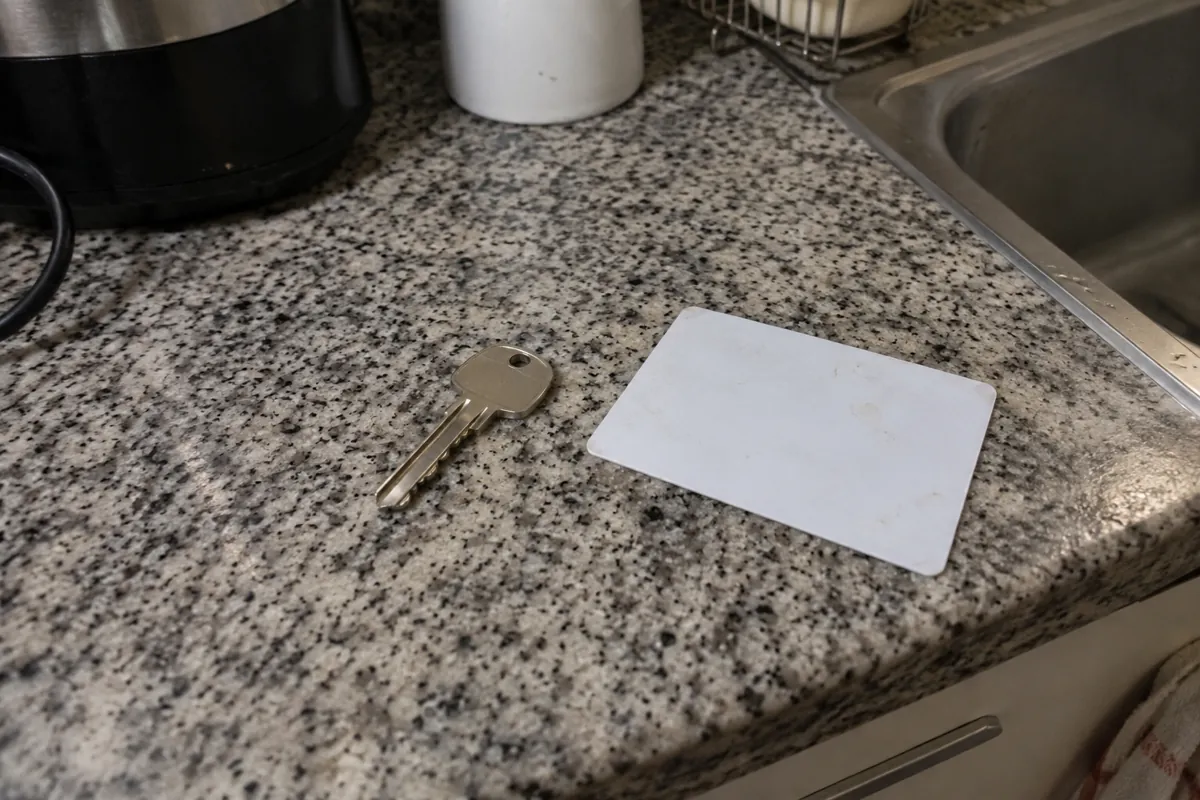 Una llave y una tarjeta blanca descansan sobre la cubierta de una cocina