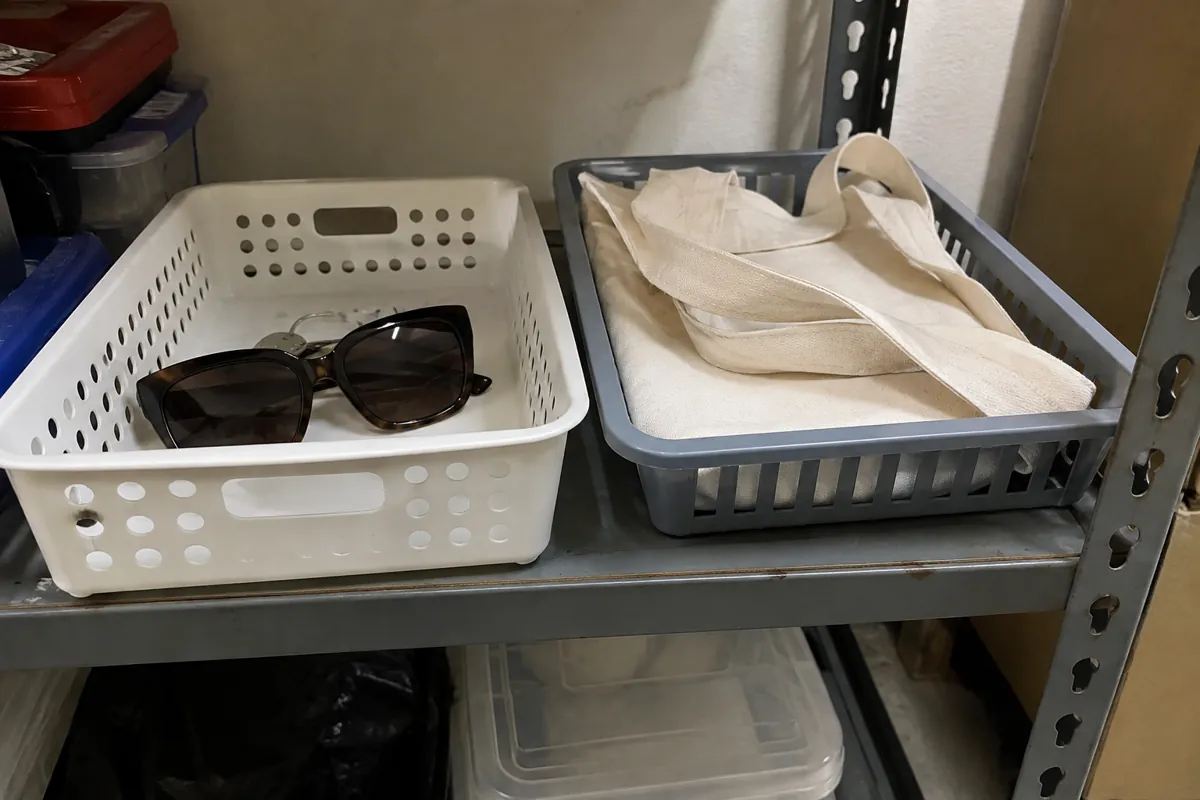 Lentes de sol y bolsa de tela guardados en canastas separadas en un estante