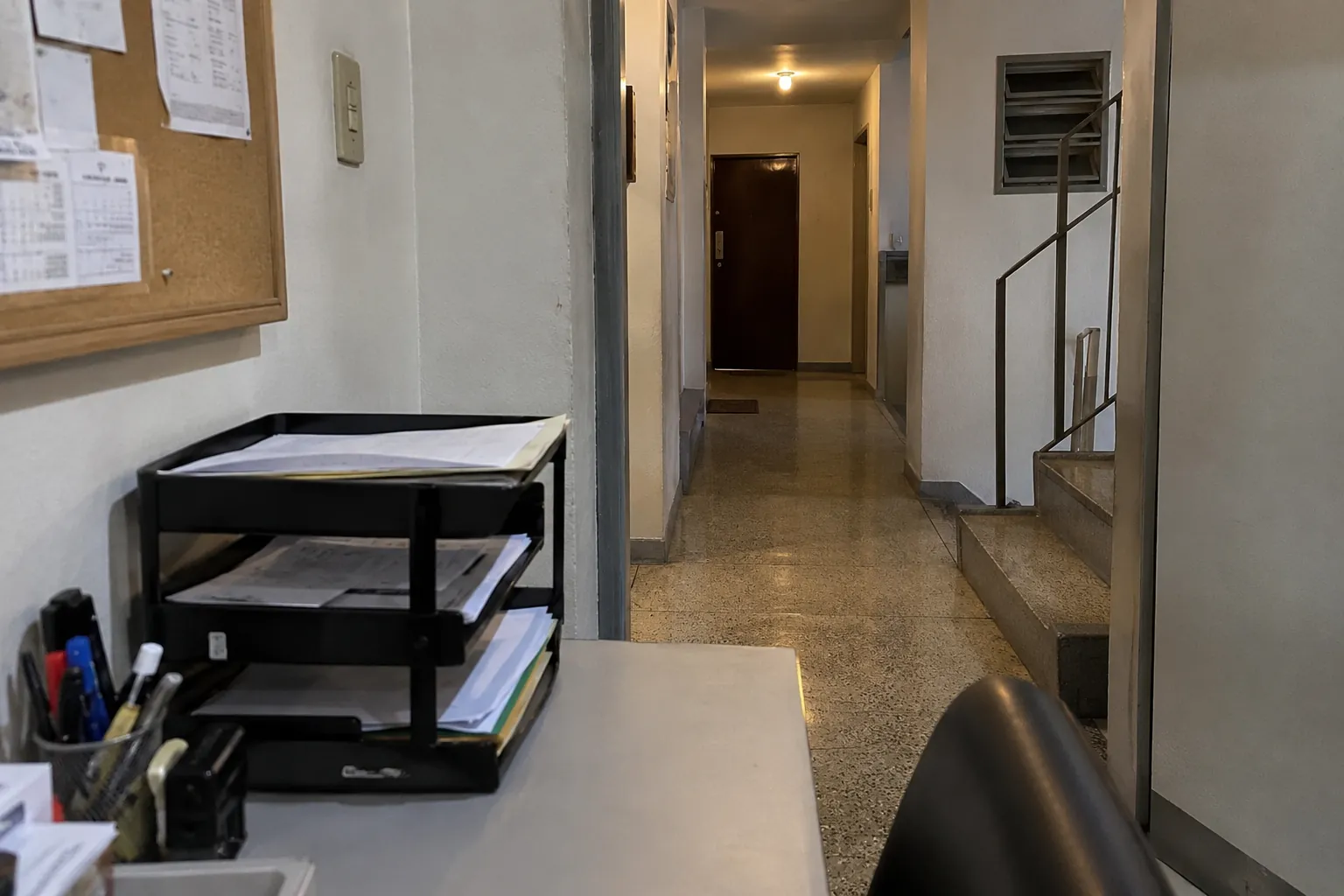Bandejas con documentos sobre un escritorio junto a un pasillo residencial