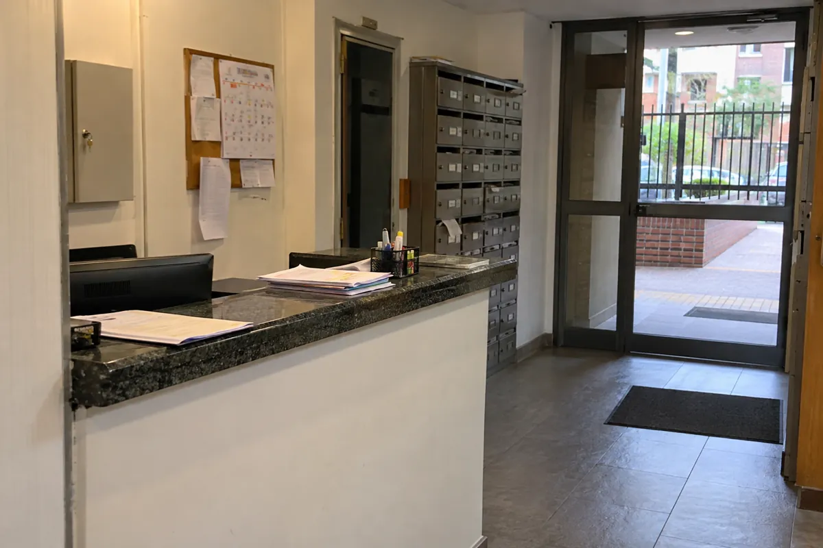 Mostrador de recepción con documentos y un calendario en la pared junto a los buzones